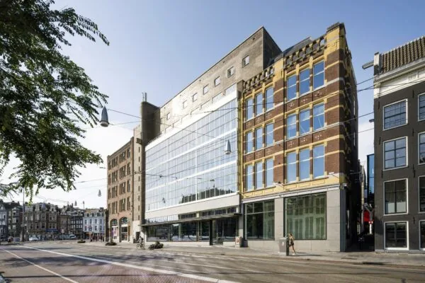 Straatbeeld van de Sint-Jorissteeg in Amsterdam met historische en moderne gevels naast elkaar.
